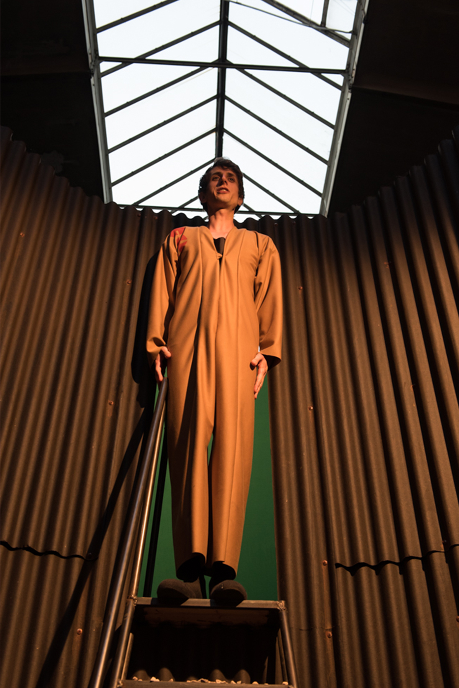 florian mania trägt einen kamelfarbenen Overall von Maylin Habig , über seinem kopf sieht man das Dach der Naxoshalle, foto von Robert Schittko