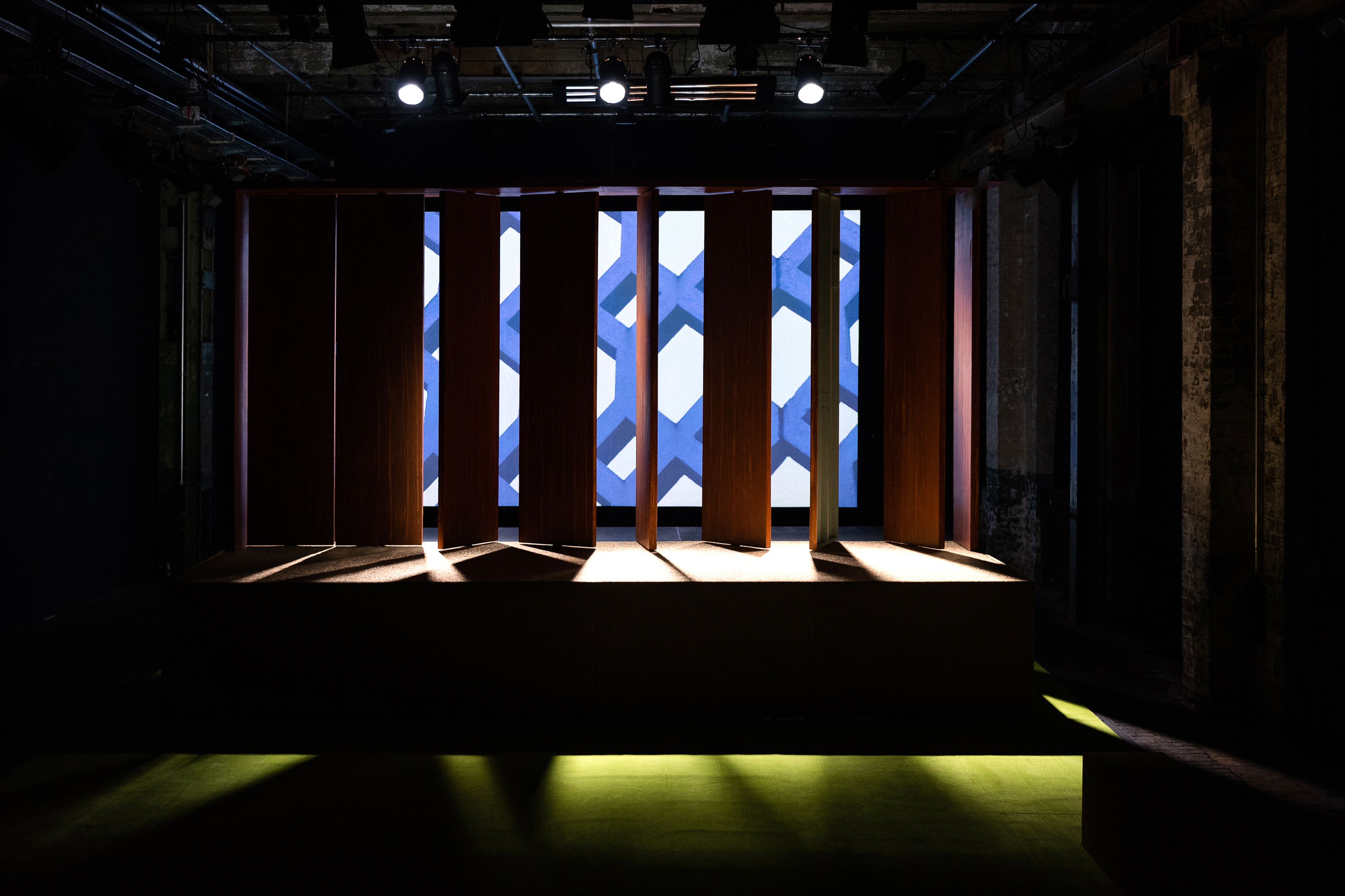 Leere Bühne, Projektion, Lamellenwand, Schatten, grüner Teppich